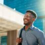 Business, happy and walking black man on city journey, commute trip and real estate agent smile on way to office building. Happiness, career expert and African real estate agent on morning travel in Nigeria