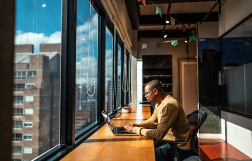 Mid adult man working using laptop at office